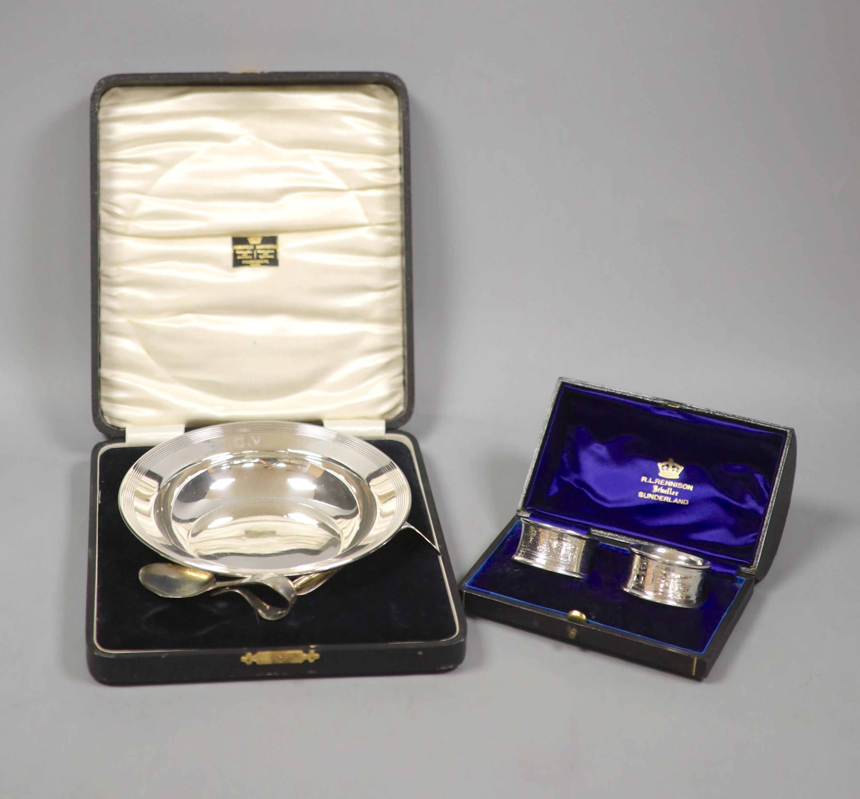 A cased christening dish with associated pusher and spoon, together with a cased pair of silver napkin rings.